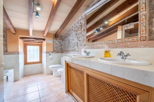 a bathroom with two sinks and a toilet at Can Pou Petit in Pollença