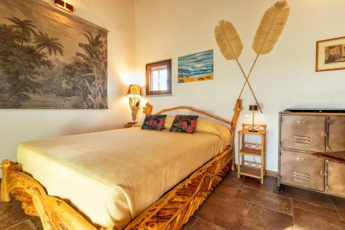 a bedroom with a large bed and a dresser at Stazzo Jana in Trinità d'Agultu e Vignola