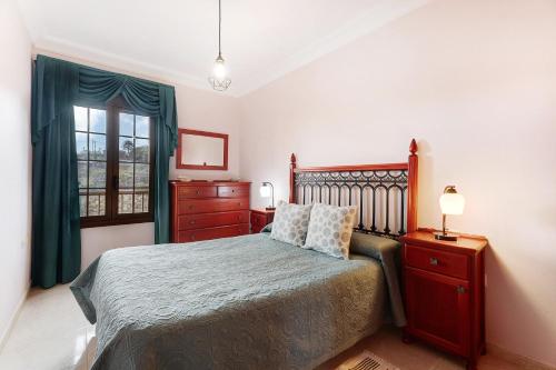 a bedroom with a bed and a dresser and a window at Casa Girdana in Valverde