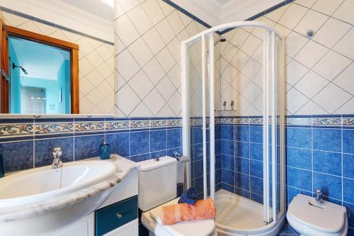 a blue tiled bathroom with a toilet and a sink at Casa Girdana in Valverde
