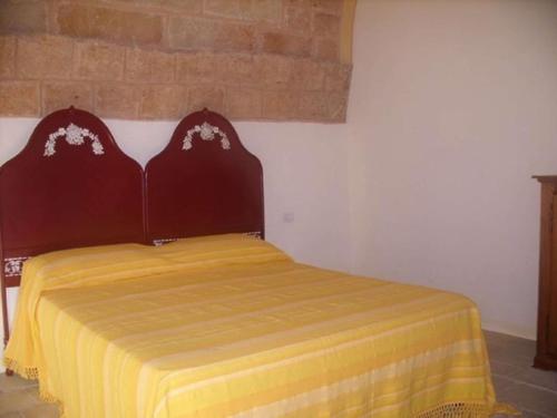 a bedroom with a bed with a yellow blanket at Lu Rusciu De Lu Vientu in Castrignano del Capo