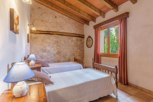 a bedroom with two beds and a table with a lamp at Son Barbudet in Campos