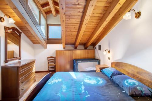 a bedroom with a large bed and a wooden ceiling at Appartamento nel borgo di Chatillon in Châtillon
