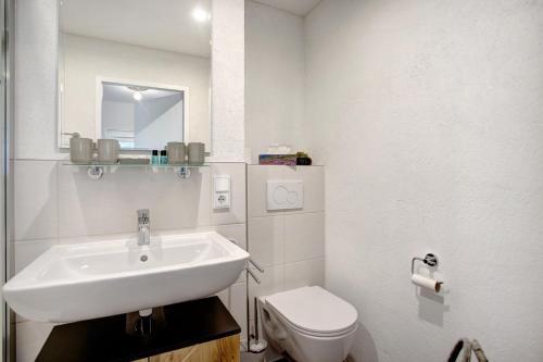 a white bathroom with a sink and a toilet at The View in Bad Reichenhall