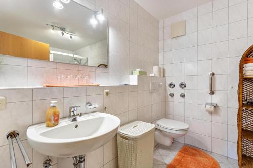 a bathroom with a sink and a toilet and a mirror at Ferienwohnung Edelweiß in Bad Reichenhall