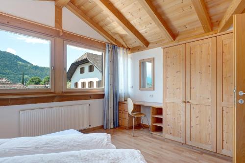 a bedroom with a bed and a desk and a window at Hofanger in Lagundo