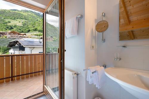 a bathroom with a tub and a sink and a window at Hofanger in Lagundo