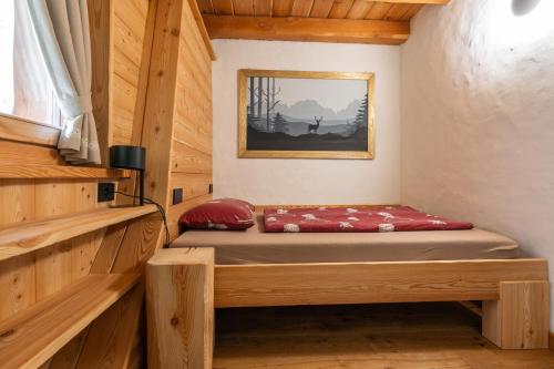 a small bedroom with a bed in a cabin at Maroc Mountain Chalet in Madonna di Campiglio