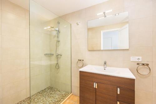 a bathroom with a shower and a sink and a mirror at Ca Na Bel in Cala Ratjada