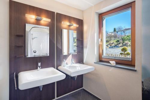 a bathroom with two sinks and a window at Lichtblick in Weiler-Simmerberg
