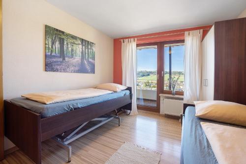 a bedroom with two beds and a window at Lichtblick in Weiler-Simmerberg