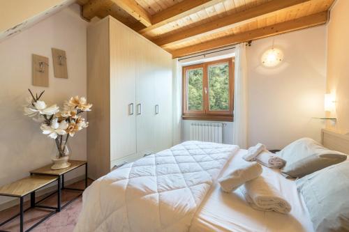 a bedroom with a white bed and a window at Residence Tatiana B3 in Tremosine Sul Garda
