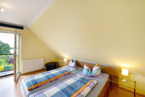 a bedroom with two beds and a large window at Großes Ferienhaus mit Seeblick in Leezen