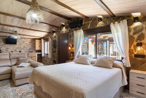 a bedroom with a large bed and a couch at Loft Abanderao Piscina y Jacuzzi in Conil de la Frontera