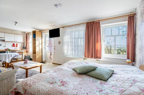 a bedroom with a bed and a table and a window at Hus Tingeltut Gerd Clausen in Pellworm