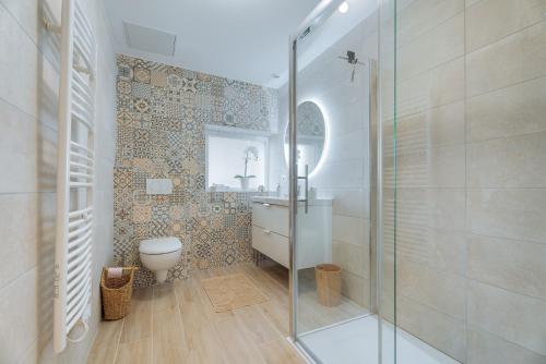 a bathroom with a glass shower and a toilet at Le Banc des Hermelles in Saint-Benoît-des-Ondes