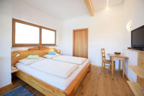 a bedroom with a wooden bed and a television at Peter Paul Studio Buchwald in Appiano Sulla Strada Del Vino