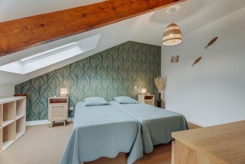 a bedroom with a bed with a blue blanket at Le Banc des Hermelles in Saint-Benoît-des-Ondes