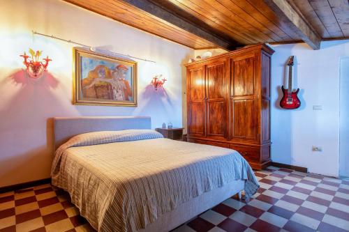 a bedroom with a bed and a guitar on the wall at Il Conte e La Contessa in Sennori