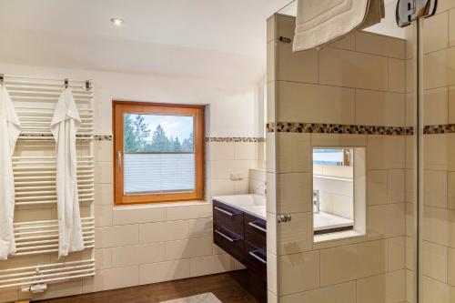 a bathroom with a shower and a sink and a window at Ferienwohnung Kraus Eibsee in Grainau