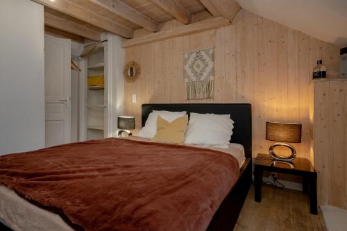 una camera da letto con un letto grande in una stanza con pareti in legno di La Villa a Viviers-du-Lac