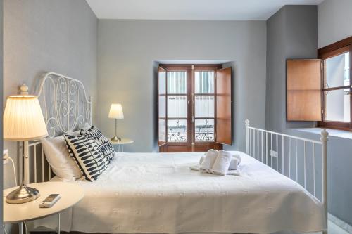 a bedroom with a large white bed and a window at Francos Cathedral in Seville