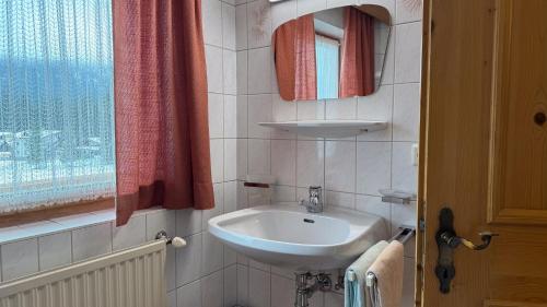 a small bathroom with a sink and a window at Birkenhof in Leutasch