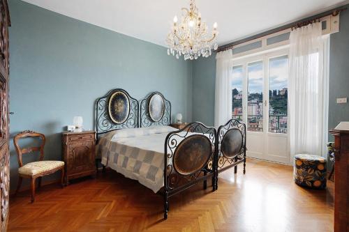 a bedroom with a bed and a chandelier at 5 Terre - Lerici - Aless View in Lerici