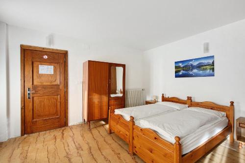 una camera da letto con un letto e una porta di legno di Albergo Trieste - Lorenzago a Lorenzago