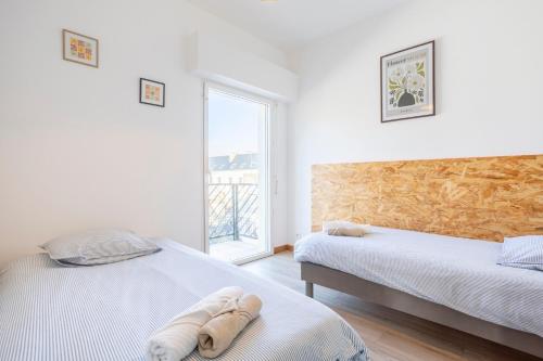 a bedroom with two beds and a window at Urania - Escale centre Concarneau in Concarneau