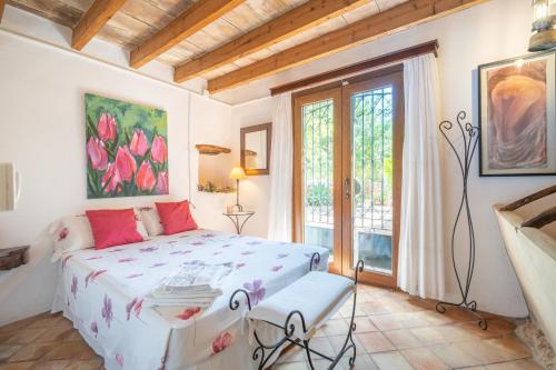 a bedroom with a bed and a large window at S Olivar Major in Fornalutx