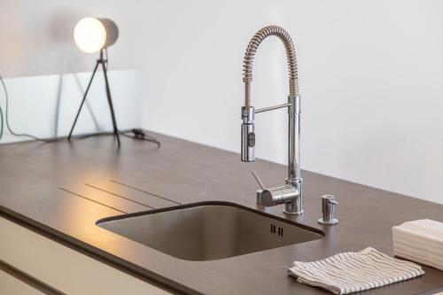 a kitchen sink with a stainless steel faucet at Urania - Escale centre Concarneau in Concarneau