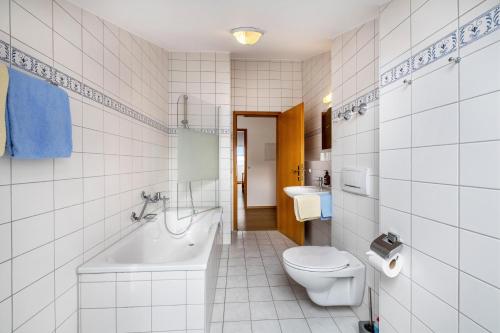 a bathroom with a toilet and a tub and a sink at Fewo Brünnstein - Zimmer 55 in Oberaudorf