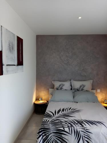 a bedroom with a bed with black and white sheets at Gîte Le Campet in Millau