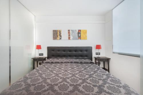 a bedroom with a large bed with two tables at Club Atlantis 159 in Adeje