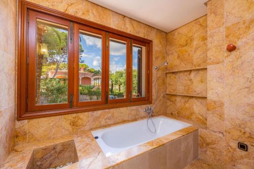 a large bathroom with a tub and a window at Gran Vista Mar in Alcudia
