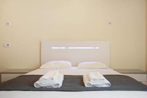 a bedroom with a bed with two towels on it at A O - Apart Passarelle in Peniche