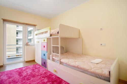 a bedroom with a bunk bed and a pink rug at A O - Apart Passarelle in Peniche