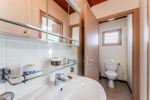 a bathroom with a sink and a toilet at Maison 3 étoiles, 300m de l’Océan in Biscarrosse
