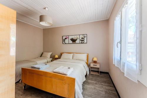 a bedroom with a large bed and a window at Maison 3 étoiles, 300m de l’Océan in Biscarrosse