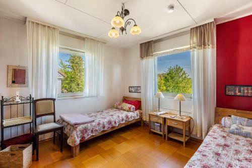 a bedroom with a bed and a couch and two windows at Ferienwohnung Oberamsel in Marburg an der Lahn