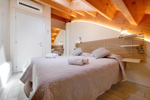 a bedroom with a large bed with a wooden headboard at Relax and Happiness private Jacuzzi in Perledo