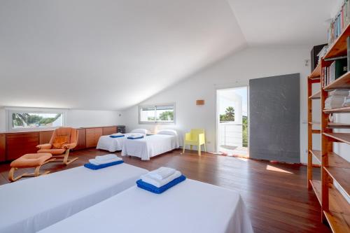 a bedroom with two beds and a book shelf at Villa Xipell 9 in Cala Santandria