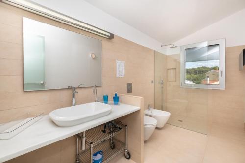 a bathroom with a sink and a toilet and a mirror at Villa Xipell 9 in Cala Santandria