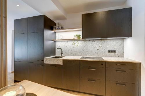 a kitchen with brown cabinets and a sink at Labe Biohof Oberzonn in Kastelruth