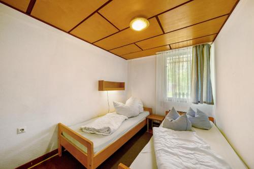a room with two beds and a window at Bungalow 17 - Kimbucht in Reichendorf