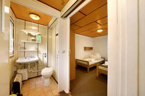 a bathroom with a toilet and a sink and a bed at Bungalow 17 - Kimbucht in Reichendorf