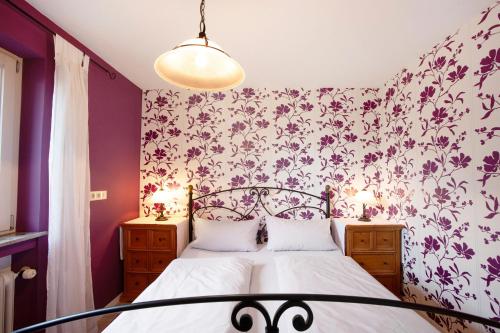 a bedroom with a bed with a floral wallpaper at Ferienwohnung Schoeneberg in Vogt