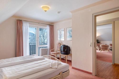 a bedroom with a bed and a balcony at Ferienhaus Adler Bellevue in Hinterzarten