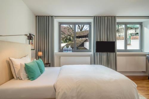 a bedroom with a large bed and two windows at 1 Zimmer-appartment Nr 11 in Wangen im Allgäu